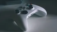 A detailed shot of a white gaming controller on a desk surface, perfect for tech and gaming themes.