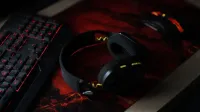 Una elegante configuración de juego con un teclado retroiluminado, auriculares inalámbricos y un mouse para juegos en una almohadilla de escritorio vibrante.