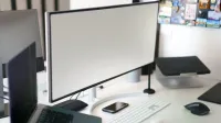 Espacio de trabajo de oficina limpio y moderno con una configuración de escritorio con un monitor grande y accesorios.