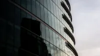 Contemporary glass office building reflecting cityscape in London, UK.