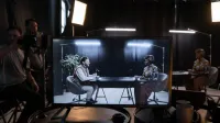 A podcast recording session in a studio with hosts in conversation, captured on screen.