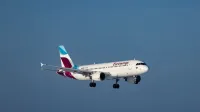 Un avión de Eurowings capturó a mitad de vuelo contra un cielo azul despejado, mostrando la dinámica de la aviación.