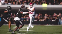 Imagen de John Mateer haciendo un pase de touchdown durante el juego de Oklahoma en el estado de Mississippi
