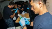 Hospital Corpsman 2nd Class Albert Delacruz fills a syringe with the flu vaccine in the medical department aboard the amphibious assault ship USS Boxer (LHD 4).