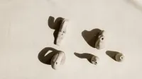 Artistic shot of handmade clay ocarinas on light background, highlighting shadows.