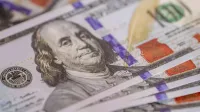 Imagen detallada de primer plano de billetes de cien dólares estadounidenses avivados, mostrando detalle de moneda.