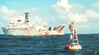 The National Oceanic and Atmospheric Administration oceanographic research ship NOAAS Kaimimoana (R 333) services an Atlas buoy in the equatorial Pacific Ocean.