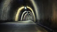 Misterioso túnel subterráneo con luces arqueadas creando una atmósfera de mal humor.