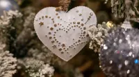 Adorno en forma de corazón en el árbol de Navidad, creando un ambiente festivo festivo.