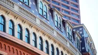 Curved facade of historic building with modern skyscraper in Boston, Massachusetts.