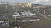 Aerial view of the Google data center at Eemshaven, Netherlands, surrounded by wind turbines with a power plant in the background