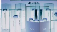 PlayStation 5 consoles and accessories on display in a sleek, futuristic showroom.