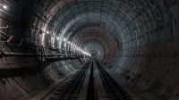 A striking perspective of an illuminated metro tunnel showcasing intricate infrastructure.