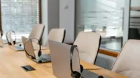 Fila de portátiles con auriculares en un moderno ambiente de oficina listo para la comunicación.