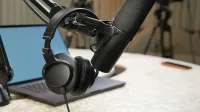Primer plano de una configuración de estudio de podcast con un micrófono y auriculares.