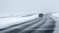 Un automóvil conduce a través de una tormenta de nieve en una carretera abierta en Broomfield, Colorado, en 2024.
