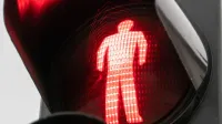 Vista detallada de una señal de cruce peatonal rojo que indica la parada.