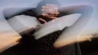 Mujer usando Oura Ring 5 con las manos en la cabeza después de un entrenamiento