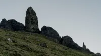 Las dramáticas formaciones rocosas se elevan contra un suave cielo gris en un paisaje montañoso escarpado.