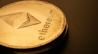 Detailed macro shot of an Ethereum logo coin against a dark background.