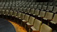 Filas curvas de asientos de teatro vacíos, perfectos para escenarios o eventos.
