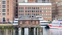 Capturado en Boston Waterfront con muelle abandonado, edificio histórico y barcos atracados durante el día.