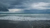 Impresionante vista de una playa tormentosa con nubes dramáticas en Nueva Zelanda.