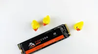 Close-up of a Seagate FireCuda SSD on a white background with three yellow rubber ducks.