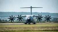 Vista frontal de un avión militar A400M en la pista contra un telón de fondo del bosque.