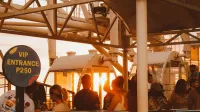 Turistas haciendo cola para un paseo en rueda de la fortuna al atardecer con señal de entrada VIP.