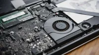 Vista detallada de los circuitos internos de una computadora portátil y del ventilador de refrigeración que muestra la tecnología y la ingeniería.