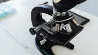 Foto detallada de un microscopio en un escritorio de laboratorio, simbolizando la investigación científica.
