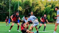 Juego de rugby lleno de acción con jugadores que abordan un campo verde.