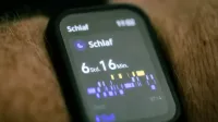 Close-up de un smartwatch que muestra los datos de seguimiento del sueño en alemán.