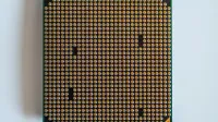 Detailed view of a computer processor, showcasing its pins, against a clean white backdrop.