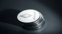 Close-up of stacked Ethereum coins on a dark textured surface, symbolizing modern cryptocurrency.