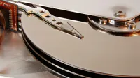 Detail of one read/write head and the platters of a Seagate 3.5 inches hard disk drive Medalist ST33232A model manufactured in Malaysia in 1998.