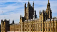 Impresionante vista del palacio histórico de Westminster en Londres bajo un cielo azul claro.
