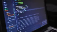 Primer plano de una pantalla de computadora que muestra el código de programación en un entorno oscuro.