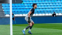 Portero en acción durante un partido de fútbol, listo para defender la portería.