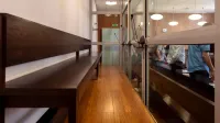 Vista interior de una sala de audiencias en Wrocław, Polonia, con bancos de madera y mamparas de vidrio.