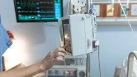 A healthcare worker operates a modern infusion pump in a hospital setting, ensuring precise medication delivery.