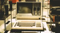 Computadora general pasada de moda en pantalla con un teclado y ranuras de disco vintage.