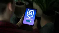 Persona que sostiene una tableta digital que muestra la pantalla de conexión blockchain en el interior.