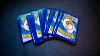 High angle of set of trading cards with images of fictional creatures placed against gray background