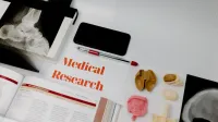 Medical research setup featuring anatomical models, x-rays, and a textbook, ideal for educational purposes.
