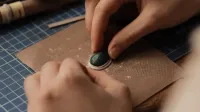Vista detallada de las manos de joyería con piedras preciosas turquesas, enfatizando la precisión y el arte.