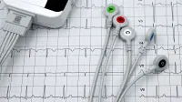 Close-up de ECG Monitor lleva en un cardiograma impreso, que muestra los diagnósticos de salud del corazón.