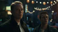 Visión y Tommy Maximoff están de pie lado a lado con expresión de preocupación y sorpresa frente a un fondo borroso de guirnaldas de luces en VisionQuest de Marvel