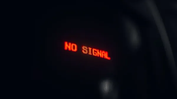 A red LED display indicating 'No Signal' in a dark setting, conveying a tech warning.